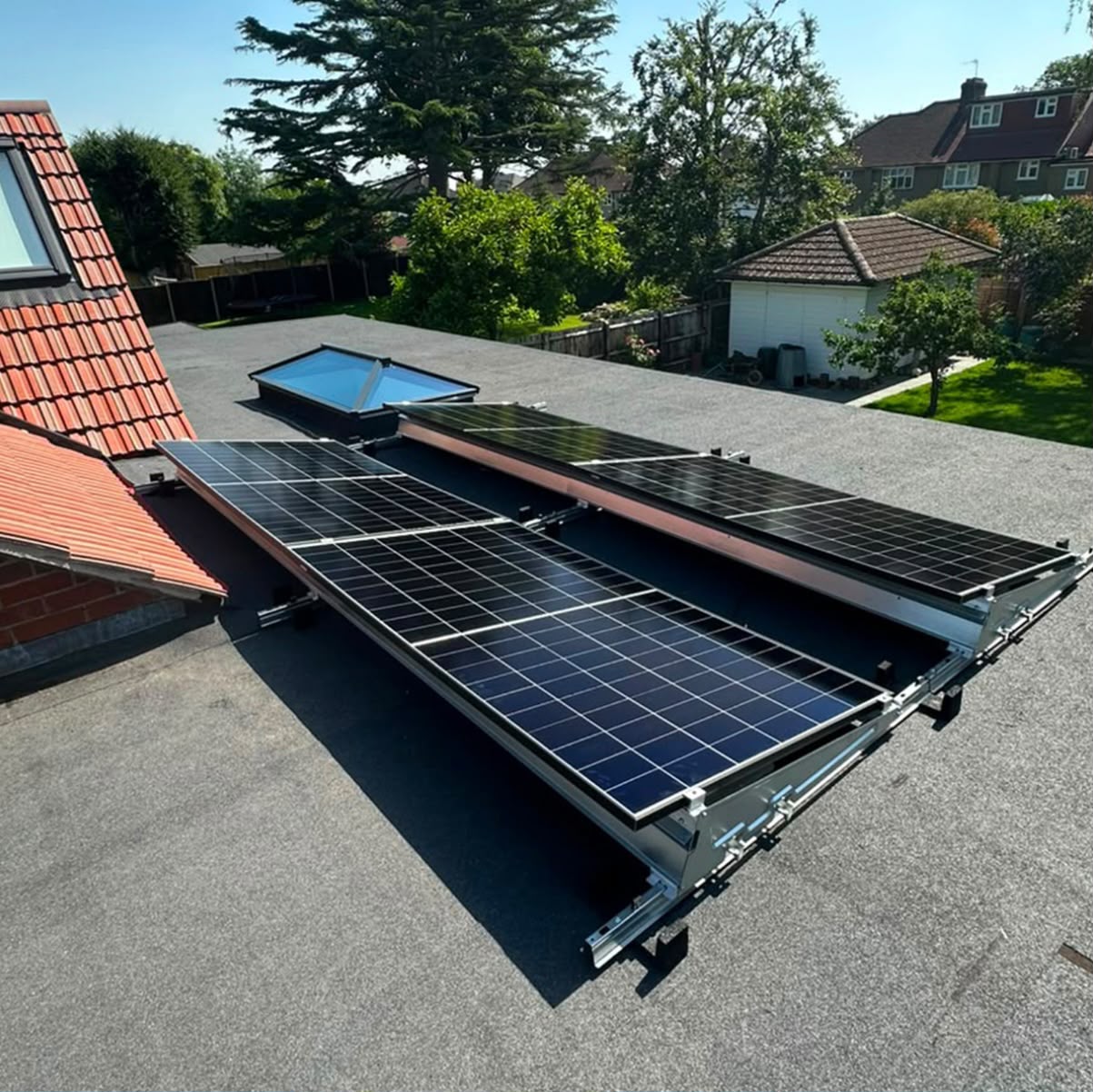 Tilted flat-roof solar panel array installed alongside a large skylight