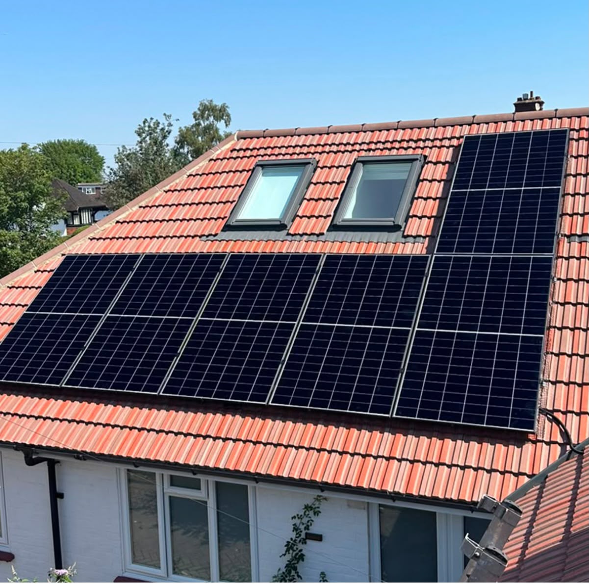 Twelve-panel residential solar PV system on a red-tile pitched roof